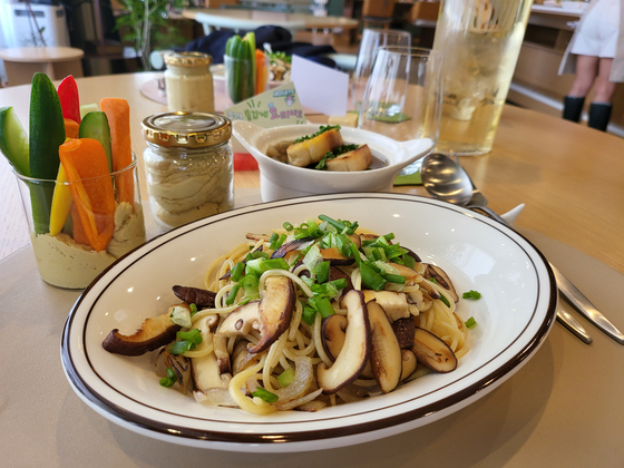 Shown clockwise: A plate of hummus with veggies, a bowl of onion soup accompanied by a baguette, and a serving of mushroom aglio e olio made by the reporter during the cooking class. [SEO JI-EUN]