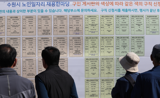 Elderly people check job vacancies and employment information posted on the board at Hwaseong Haenggung in Suwon, Southern Gyeonggi on Wednesday. [YONHAP]