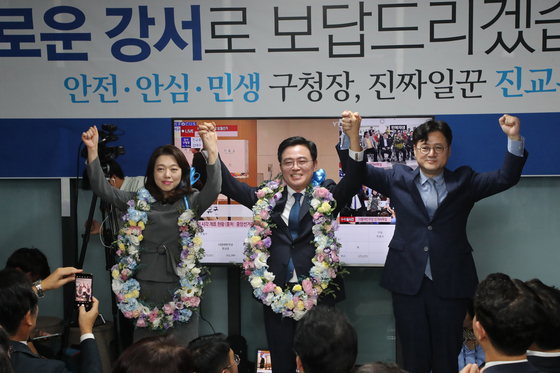 Jin Kyo-hoon, center, of the Democratic Party, celebrates at his office in western Seoul over his victory in the by-election to head Gangseo District Office late Wednesday. [YONHAP]