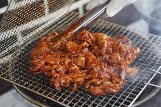 Pork bulgogi is grilled over a briquette fire for a richer taste at restaurants on Byeongyeong Pork Bulgogi Street in Gangjin County, South Jeolla. [KOREA TOURISM ORGANIZATION]