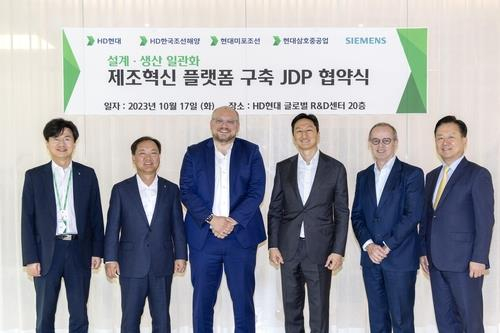 Representatives of HD Hyundai and Siemens pose for a photo after signing a deal on smart shipyards at HD Hyundai's global research and development center in Seongnam, south of Seoul, on Tuesday. [HD HYUNDAI]