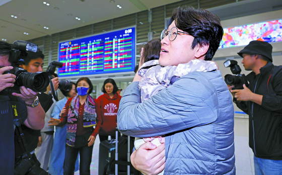 A father hugs his daughter, just returning from a short-term visit to Israel, at the Incheon International Airport on Wednesday. He was among 192 Koreans who flew out of Israel on the first direct flight to Korea since the attack by the Hamas militant group on Saturday. [NEWS1]