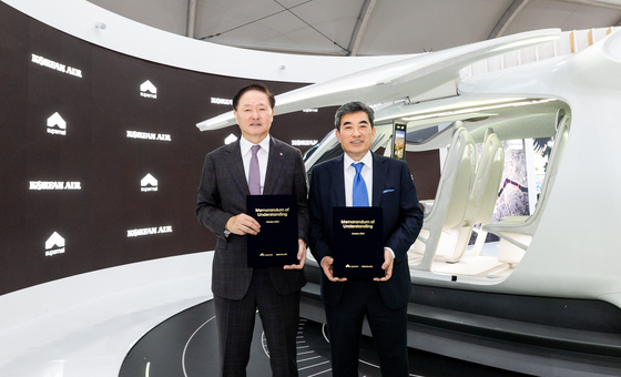 Korean Air Lines President Woo Kee-hong, left, and Supernal CEO Shin Jai-won pose for a photo after signing an MOU for the collaboration on the establishment of the UAM operational system at the Seoul ADEX 2023 on Tuesday. [KOREAN AIR LINES]