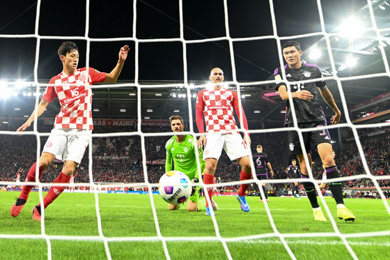Bayern Munich's Kim Min-jae, right, and Mainz's Lee Jae-sung, left, react after Mainz's Anthony Caci's goal during a Bundesliga game at Mewa Arena in Mainz, Germany on Saturday.  [AFP/YONHAP]