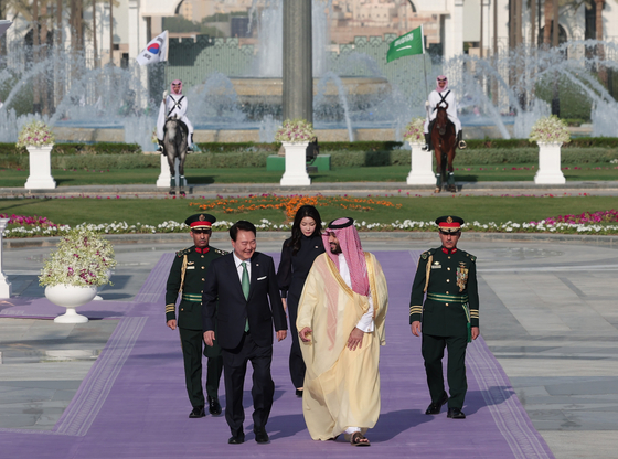 Korean President Yoon Suk Yeol, center left, and Saudi Crown Prince Mohammed bin Salman, center right, accompanied by first lady Kim Keon Hee, chat during an official welcoming ceremony at the Al Yamamah Palace in Riyadh on Sunday. [JOINT PRESS CORPS]