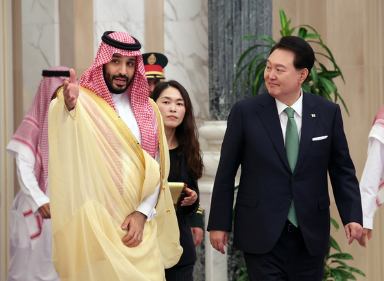 Korean President Yoon Suk Yeol, right, and Saudi Crown Prince Mohammed bin Salman head toward a memorandum of understanding signing ceremony after their bilateral summit at the Al Yamamah Palace in Riyadh on Sunday. [JOINT PRESS CORPS]
