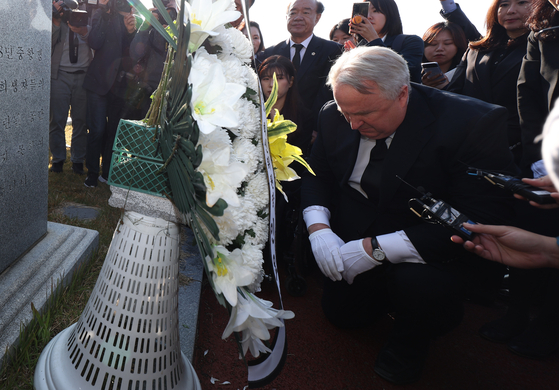 People Power Party's innovation committee head Ihn Yo-han, John Linton, kneels in front of the tomb of people still missing during the Gwangju Uprising in 1980 at the memorial in Gwangju on Monday. {YONHAP]