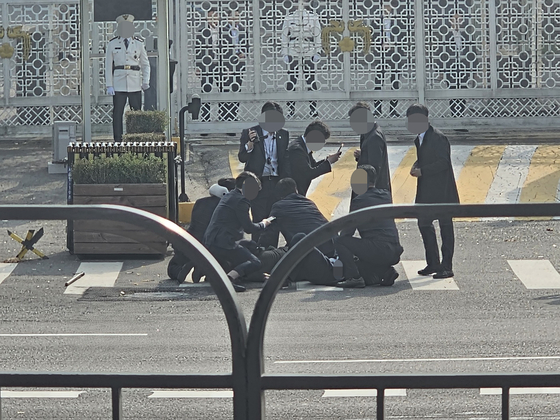 Police officers and security takes down a 77 year-old man only identified as Park, in front of the President's office in Yongsan, Seoul Tuesday. The man attacked with a knife. [YONHAP]
