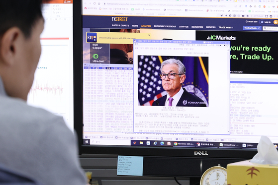 An employee at Hana Bank in central Seoul reads an article on the U.S. Federal Reserve’s decision to hold the rate unchanged in the 5.25 percent to 5.50 percent range on Thursday. [YONHAP]