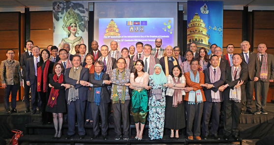Cambodian Ambassador to Korea Chring Botumrangsay, fifth from front left, join hands with ambassadors and diplomats in Korea at Conrad Seoul on Thursday to celebrate the 70th anniversary of the Independence Day of Cambodia and the 26th anniversary of Cambodia-Korea relations. [PARK SANG-MOON]