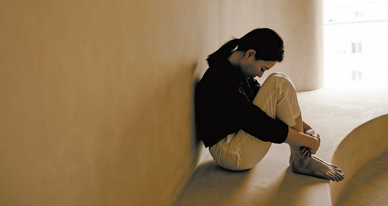 A young woman sits alone with nobody around. [JOONGANG PHOTO]