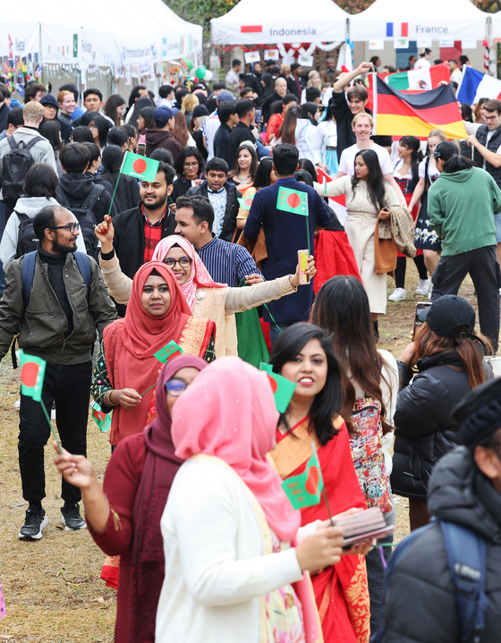  Foreign students, some wearing their home countries' traditional clothes, participate in the "Ajou International Day" parade at Ajou University in Suwon, Gyeonggi, on Thursday. [YONHAP]