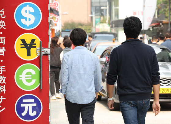 Pedestrians walk past a currency exchange shop in Myeong-dong, central Seoul, on Oct. 26. [YONHAP]