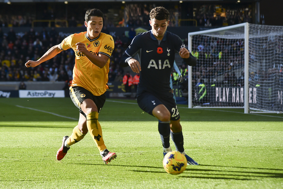 Wolverhampton Wanderers' Hwang Hee-chan, left, duels for the ball with Tottenham's Brennan Johnson during a Premier League match at Molineux in Wolverhampton, England on Saturday.  [AP/YONHAP]
