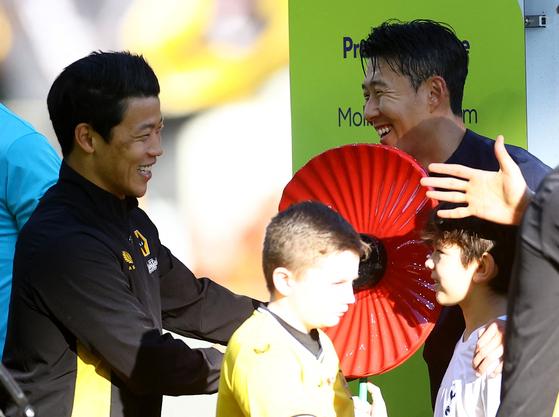 Wolverhampton Wanderers' Hwang Hee-chan, left, and Tottenham Hotspur's Son Heung-min greet each other before a Premier League match at Molineux in Wolverhampton, England on Saturday.  [REUTERS/YONHAP]