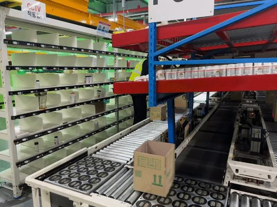 Using the QPS (Quick Picking System), boxes containing order details travel along the conveyor belt to reach the workers. After confirming the order information, the workers simply place the products into the box in front of them. [SEO JI-EUN]