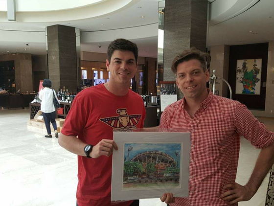 Andy Brown, right, poses with former Lotte Giants pitcher Brooks Raley and a print of his painting of Sajik Baseball Stadium in Busan.  [ANDY BROWN]