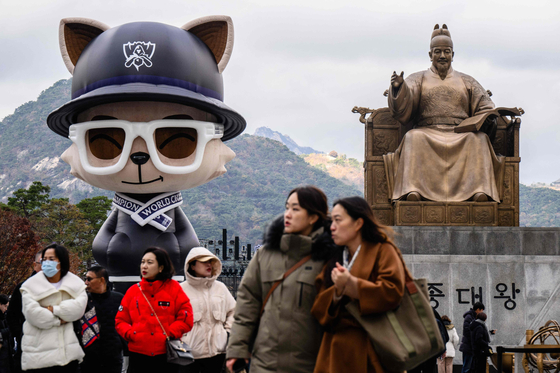 People walk in front of a temporarily installed ″Teemo″ at the ″Fan Fest″ for the 2023 League of Legends World Championship at Gwanghwamun Square in central Seoul on Friday. [AFP/YONHAP]
