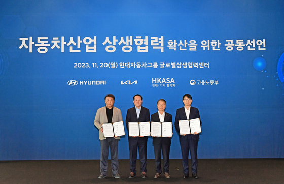Officials from Hyundai Motor, Kia and the Ministry of Employment and Labor take a photo after signing an agreement to improve their cooperation with subcontractors. [HYUNDAI MOTOR]