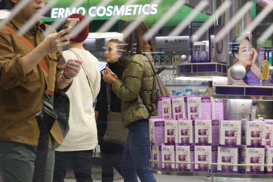 Travelers shop in Myeong-dong in central Seoul on Nov. 6. [YONHAP] 