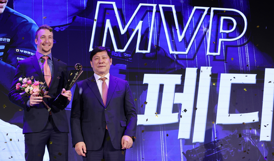 NC Dinos' Erick Fedde, left, stands next to KBO President Heo Gu-yeon after winning the MVP award in central Seoul on Monday. [NEWS1]