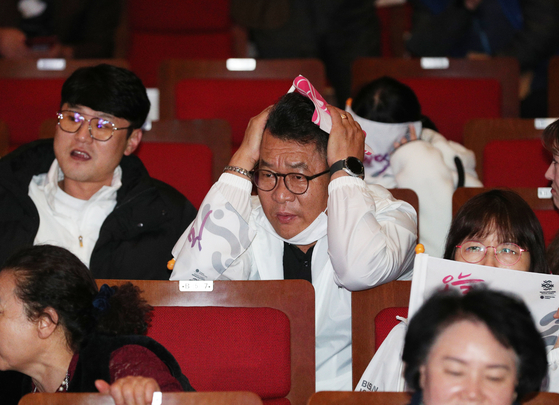 A man at the pep rally looks at the screen broadcasting the final decision confirming Riyadh as the host of World Expo 2030. [NEWS1] 