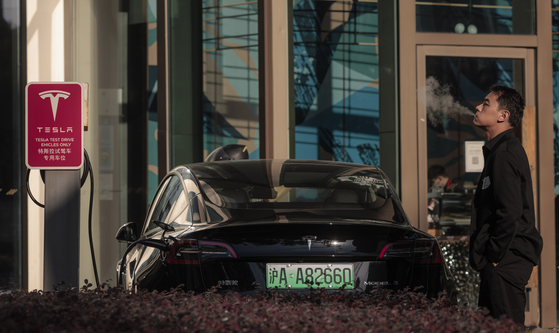 A Tesla is charged at an EV station in Shanghai, China. [EPA/YONHAP]