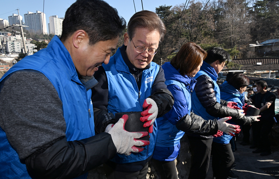 Democratic Party leader Lee Jae-myung volunteers to deliver briquettes to low-income households in Seongbuk District, Seoul, on Monday. [JOINT PRESS CORPS]