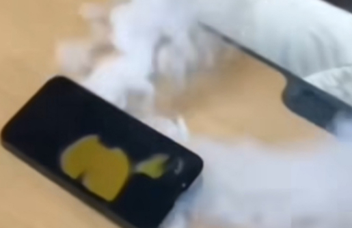 In this video, taken and uploaded by a friend of the pictured iPhone's owner, the phone is seen letting out large amounts of smoke inside a classroom at a high school in Cheonan, South Chungcheong, on Thursday. [SCREEN CAPTURE]