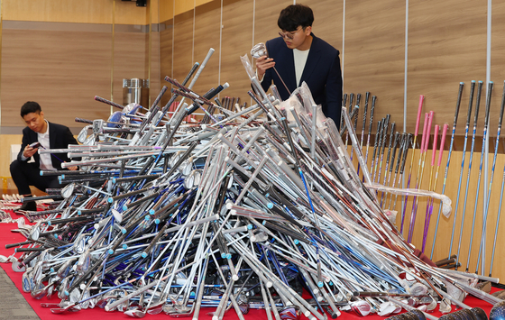 Customs officers examine fake golf clubs smuggled from China at Incheon Regional Customs headquarters on Wednesday. The seized golf clubs were purchased by a smuggler who smuggled some 746 golf club sets from AliExpress since 2021. [YONHAP] 