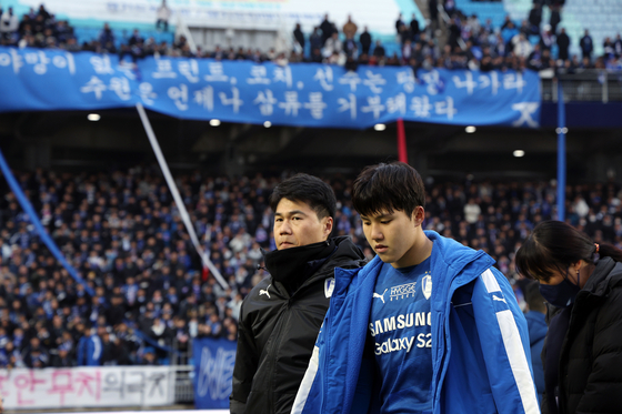 Suwon Samsung Bluewings' Kim Joo-chan, right, exits the pitch after his team's relegation to the K League 2 after a goalless draw with Gangwon FC on Dec. 2. [NEWS1]