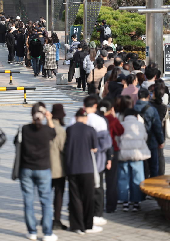 College Scholastic Ability Test (CSAT) takers and their parents wait in a long queue to enter an admission info session hosted by CSAT preparation cram school Jongro Academy at Sungkyunkwan University in Jongno District, central Seoul on Sunday. The CSAT results were announced on Friday. [YONHAP]