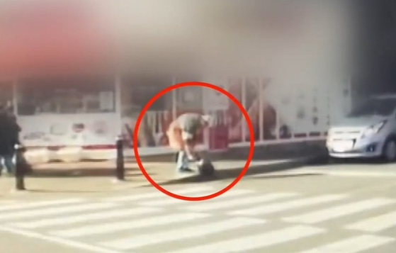An employee from a tanghulu store pours sugar syrup into the drainage on the road in Yongin, Gyeonggi on Dec. 3. [SCREEN CAPTURE]