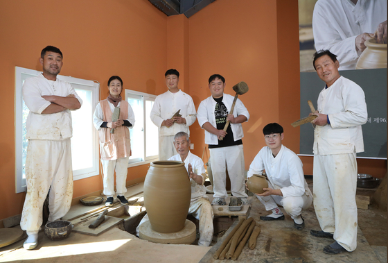 Kim poses for a photo with his sons and daughter-in-law while working on onggi. [PARK SANG-MOON]