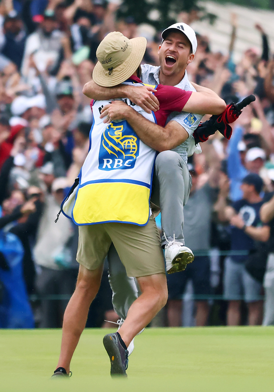 Nick Taylor of Canada celebrates with his caddie after making an eagle putt on the fourth playoff hole to win the RBC Canadian Open at Oakdale Golf & Country Club on June 11, 2023 in Toronto, Ontario. [GETTY IMAGES]