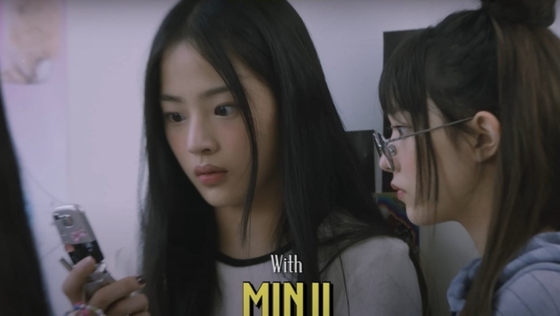 Minji of NewJeans seen holding up a feature phone in YouTube video [YOUTUBE SCREEN CAPTURE]