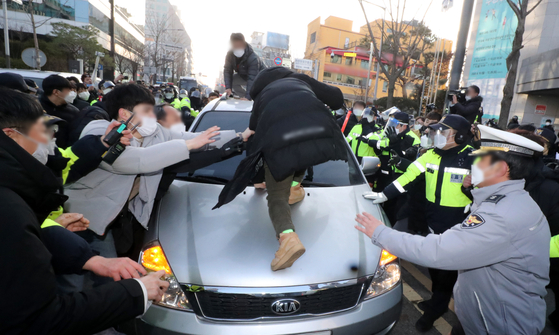 Residents of Ansan, Gyeonggi, try to block a government-owned vehicle carrying convicted child rapist Cho Doo-soon to his home in the city upon his release from prison on Dec. 12, 2020. [YONHAP]