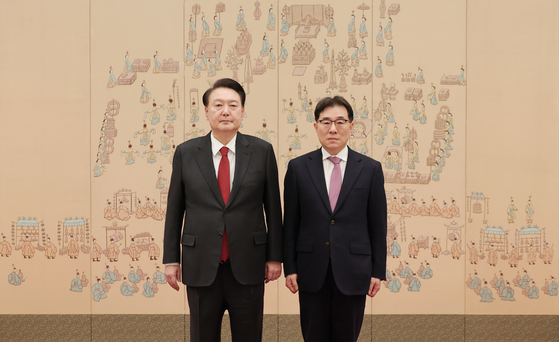 President Yoon Suk Yeol, left, is pictured with Lim Jong-in, the chair professor of information security at Korea University's graduate school, at the presidential office in Yongsan District, central Seoul, on Tuesday. [PRESIDENTIAL OFFICE]