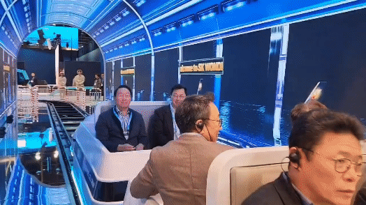 SK Group Chairman Chey Tae-won, left and SK On Executive Vice Chairman Chey Jae-won, ride hydrogen fuel cell-powered train at the SK booth on Tuesday, local time. [JIN EUN-SOO]