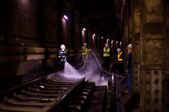 Seoul Metro employees clean a tunnel near City Hall Station along subway line No. 1 in downtown Seoul on April 1, 2023. [SEOUL METRO] 