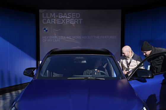 People look in a car used to demonstrate BMW's in-car personal assistant that uses Amazon's Alexa to answer questions about its cars at the BMW booth during the CES tech show Wednesday in Las Vegas. [AP/YONHAP]