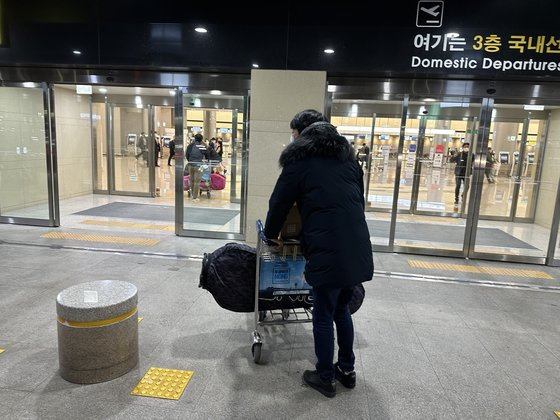 A golfer heads into Jeju International Airport to return home after playing golf on Jeju Island over winter break recently. [CHOI CHOONG-IL]