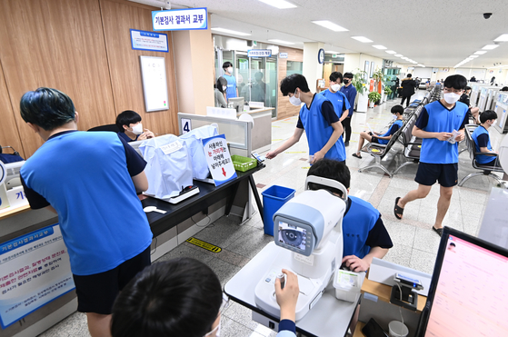 Dressed in blue, potential conscripts undergo physical examinations at a regional Military Manpower Administration testing center in Suwon, Gyeonggi, on Feb. 7, 2022. [JOINT PRESS CORPS]