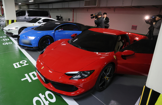 Luxury vehicles allegedly bought with proceeds from an illegal gambling website are lined up in an underground parking garage after being confiscated by prosecutors in Busan on Monday. [SONG BONG-GEUN]