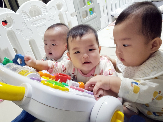Kim's triplets play with toys at their home in Gangjin County, South Jeolla. [HWANG HEE-KYU / JOONGANG PHOTO]