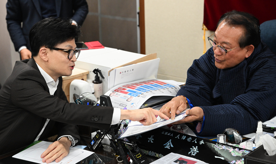 People Power Party interim leader Han Dong-hoon, left, speaks with Korea Senior Citizens Association Chairman Kim Ho-il at the association's office located in Yongsan District, central Seoul, on Jan. 3. [NEWS1] 