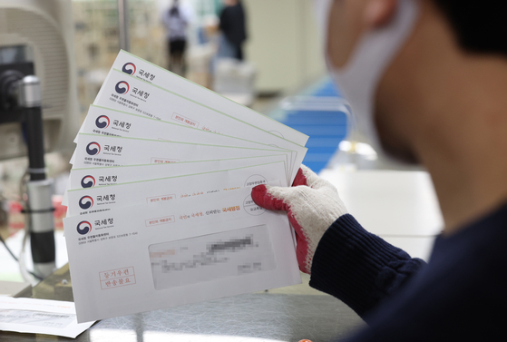 An employee categorizes tax bills at a post office in Gangnam District, southern Seoul, on Nov. 24. [YONHAP]