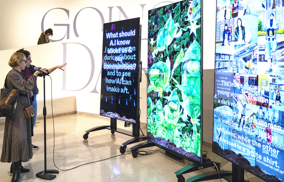 Visitors look at artist Stephanie Dinkins' artworks dubbed "The Stories We Tell Our Machines, work in progress" displayed through LG's OLED panels presented at the New York-based Guggenheim Museum. [ED MARSHALL]