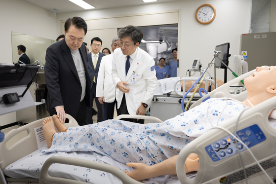 President Yoon Suk Yeol, left, visits Seoul National University Bundang Hospital’s smart simulation center for clinical training after presiding over a public livelihood debate on medical reform at the hospital in Seongnam, Gyeonggi, on Thursday. [PRESIDENTIAL OFFICE]