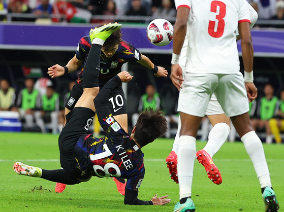 Lee Jae-sung attempts a header behind Lee Kang-in, who tries a scissor kick. [YONHAP]